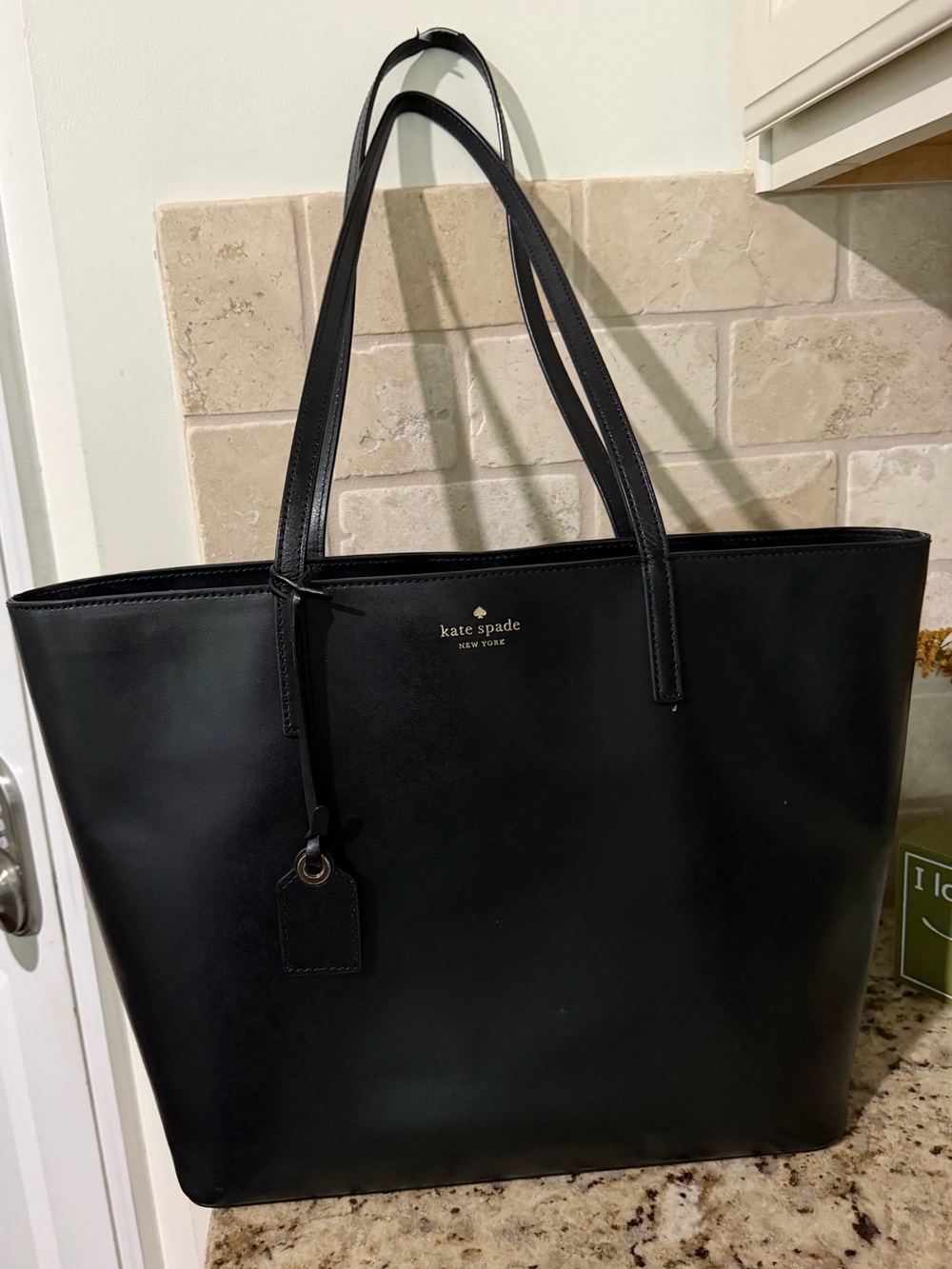 kate spade black leather tote with luggage tag